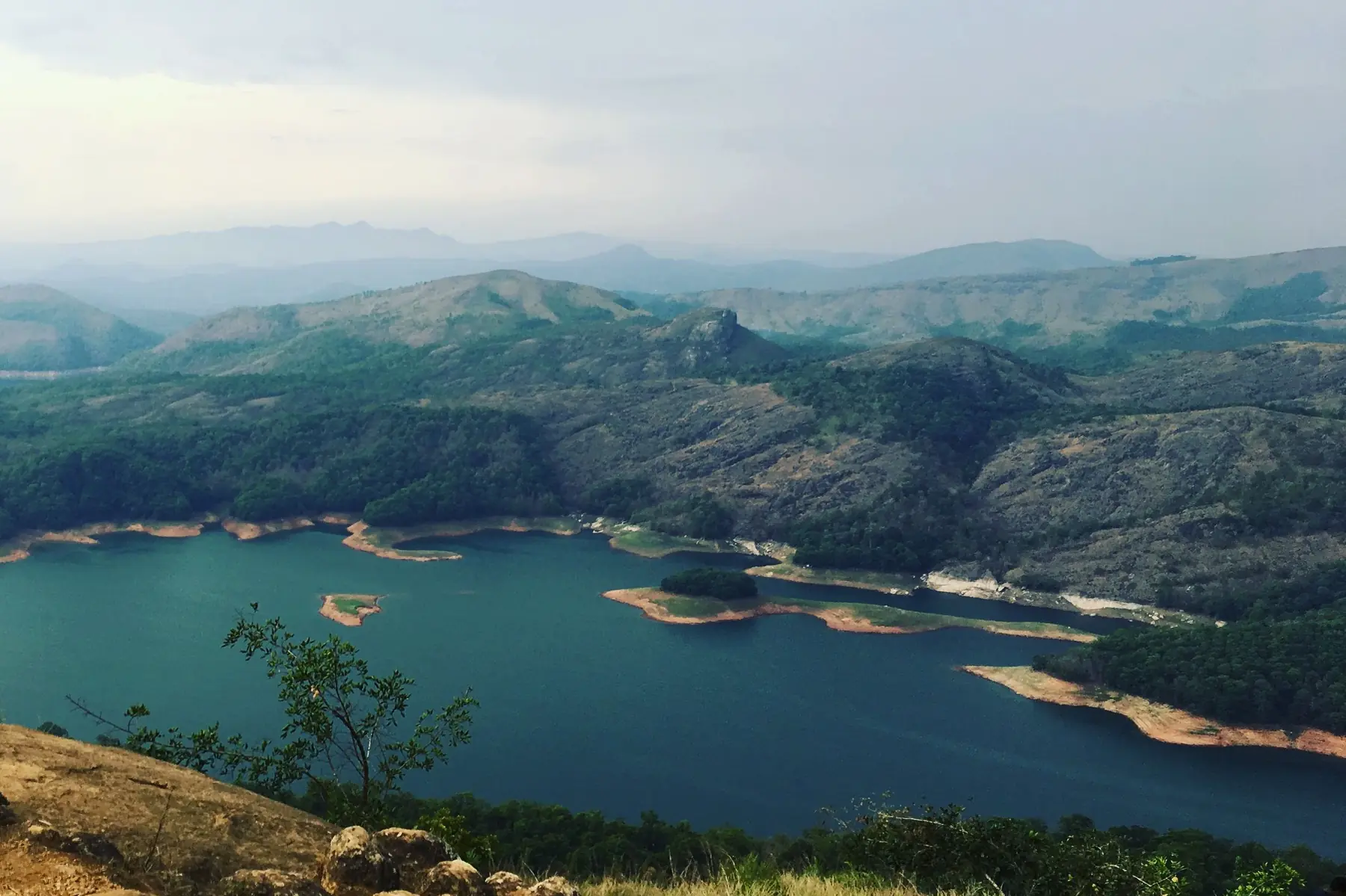 Green hills around a reservoir in Kerala's Western Ghats